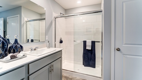 Model home primary bathroom with double vanity and shower