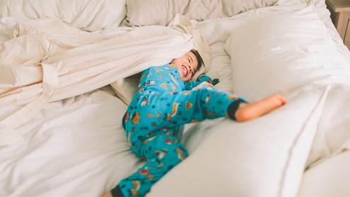 boy in bed laughing lifestyle photo