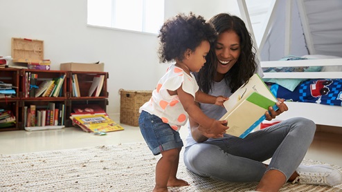 mother reading infant daughter book