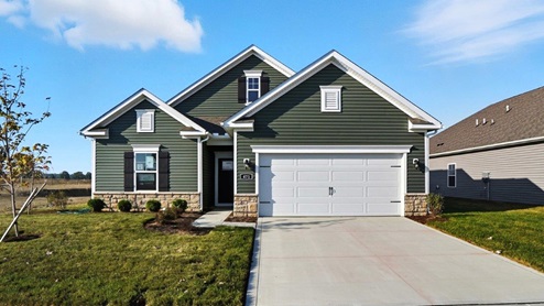 Single story home with green siding, stone water table and two car garage