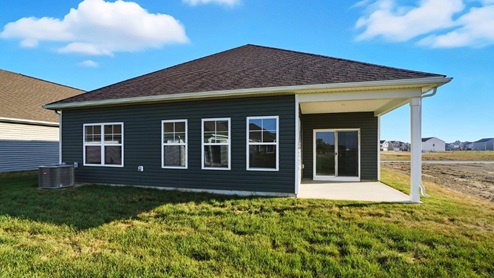 single story home with green siding and covered rear patio
