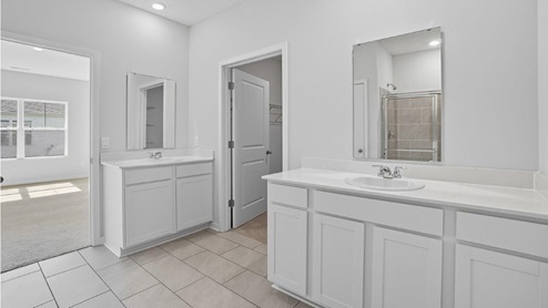 ensuite bath with separate vanities, walk in closet