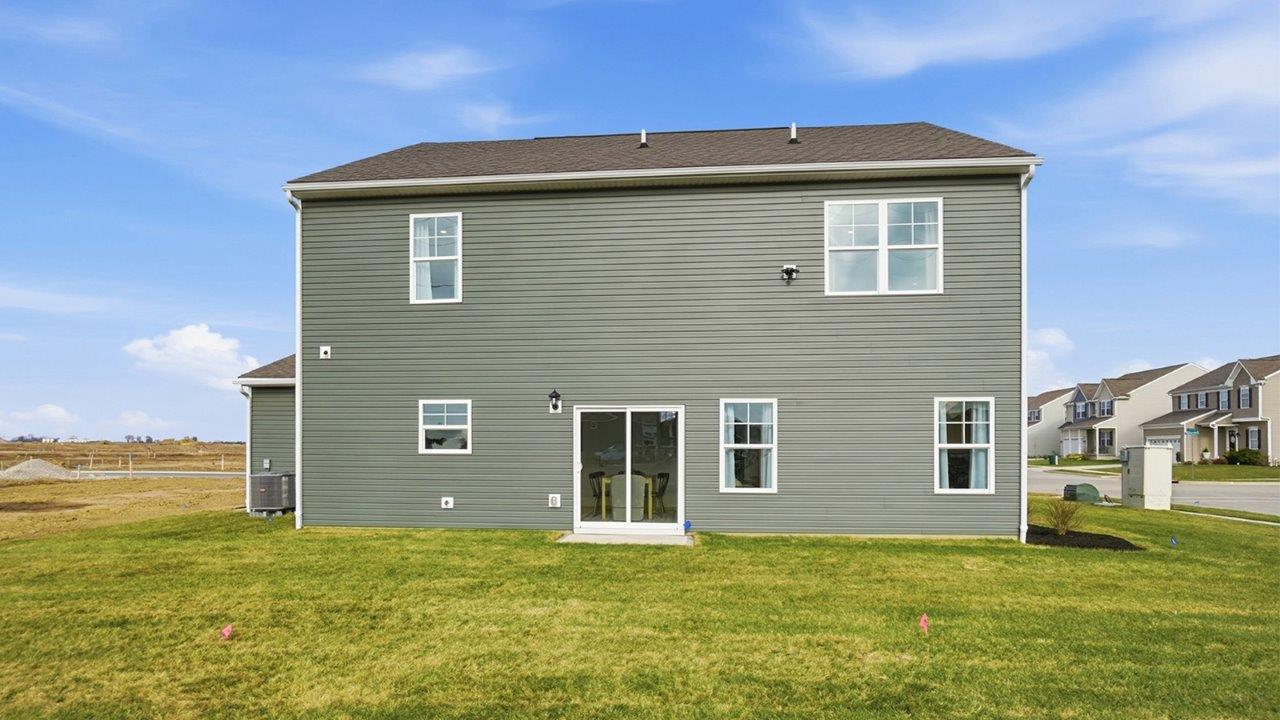 two story model home with green siding rear exterior
