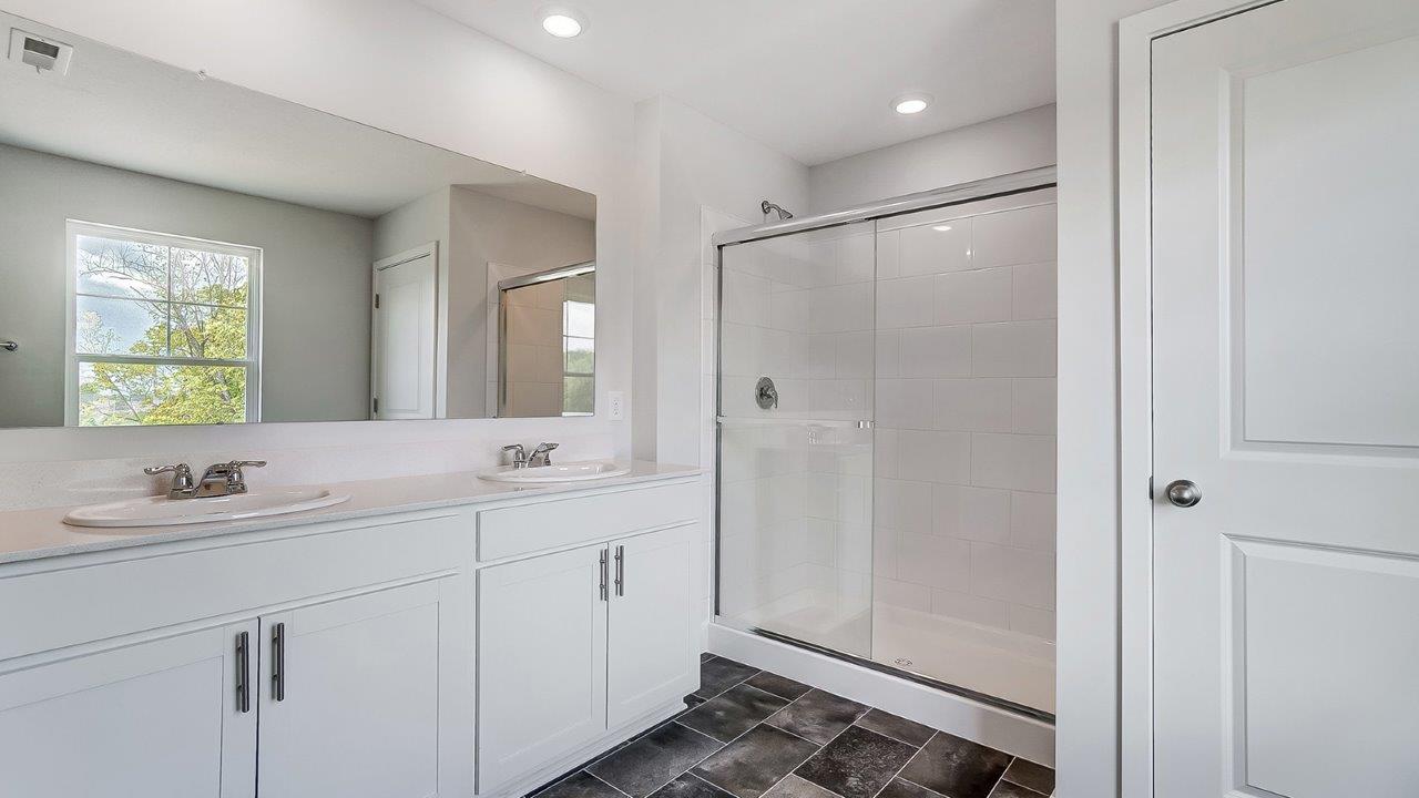 ensuite bath with double vanity, walk in shower and water closet