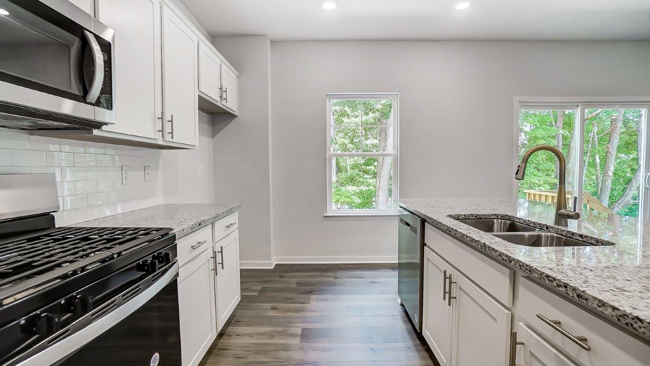 white kitchen cabinets, stainless steel appliances, hard surface counters and single window