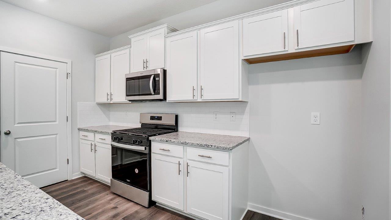 kitchen with white cabinets, stainless steel appliances, hard surface counters and walk in pantry