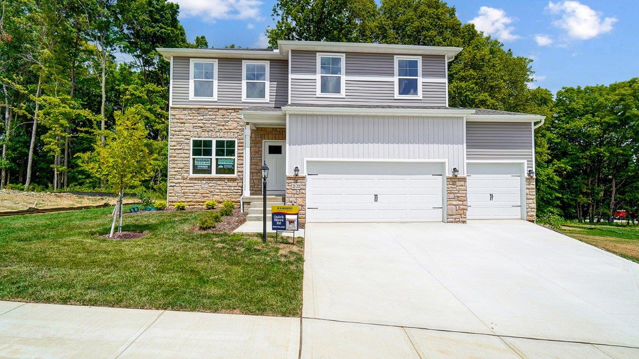 two story home with grey siding, partial stone front, covered entry and three car garage
