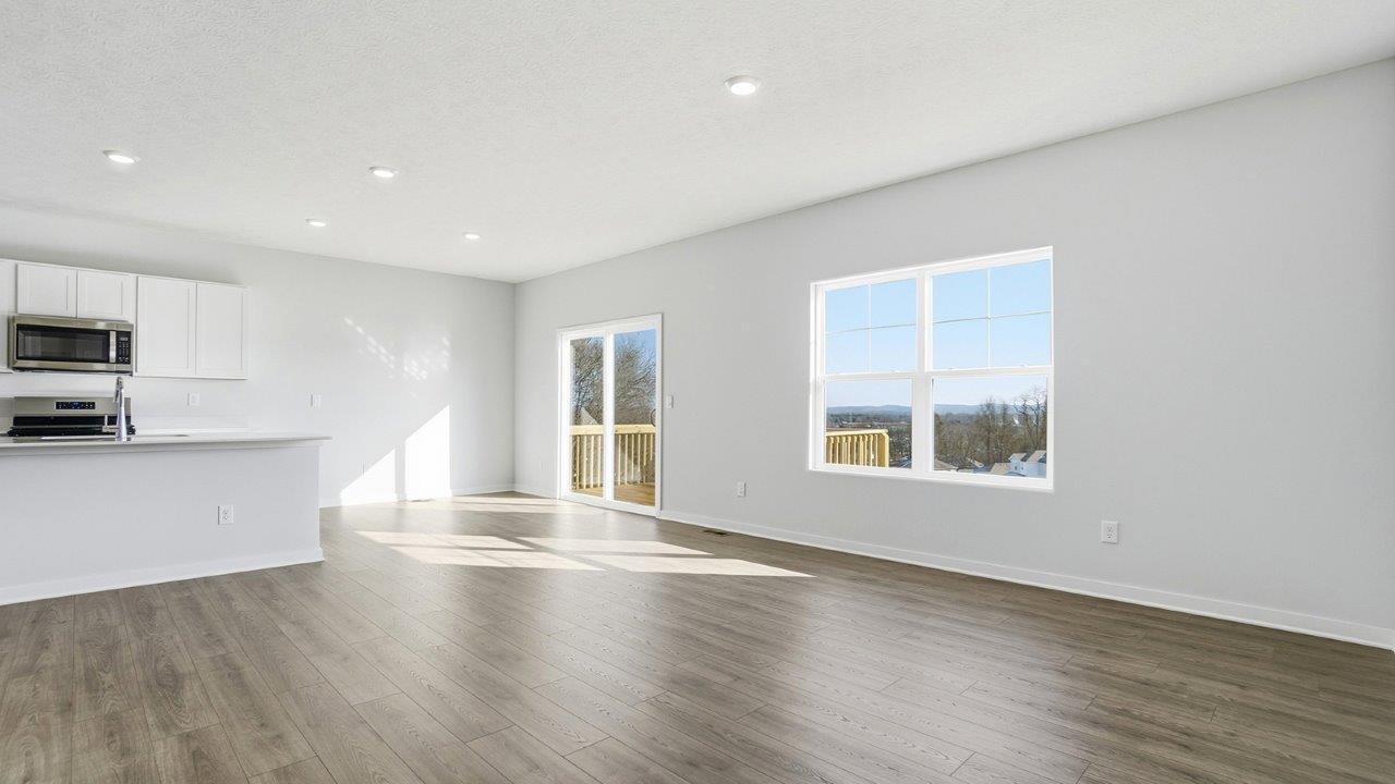 great room with double window, dining space with rear sliding door, kitchen