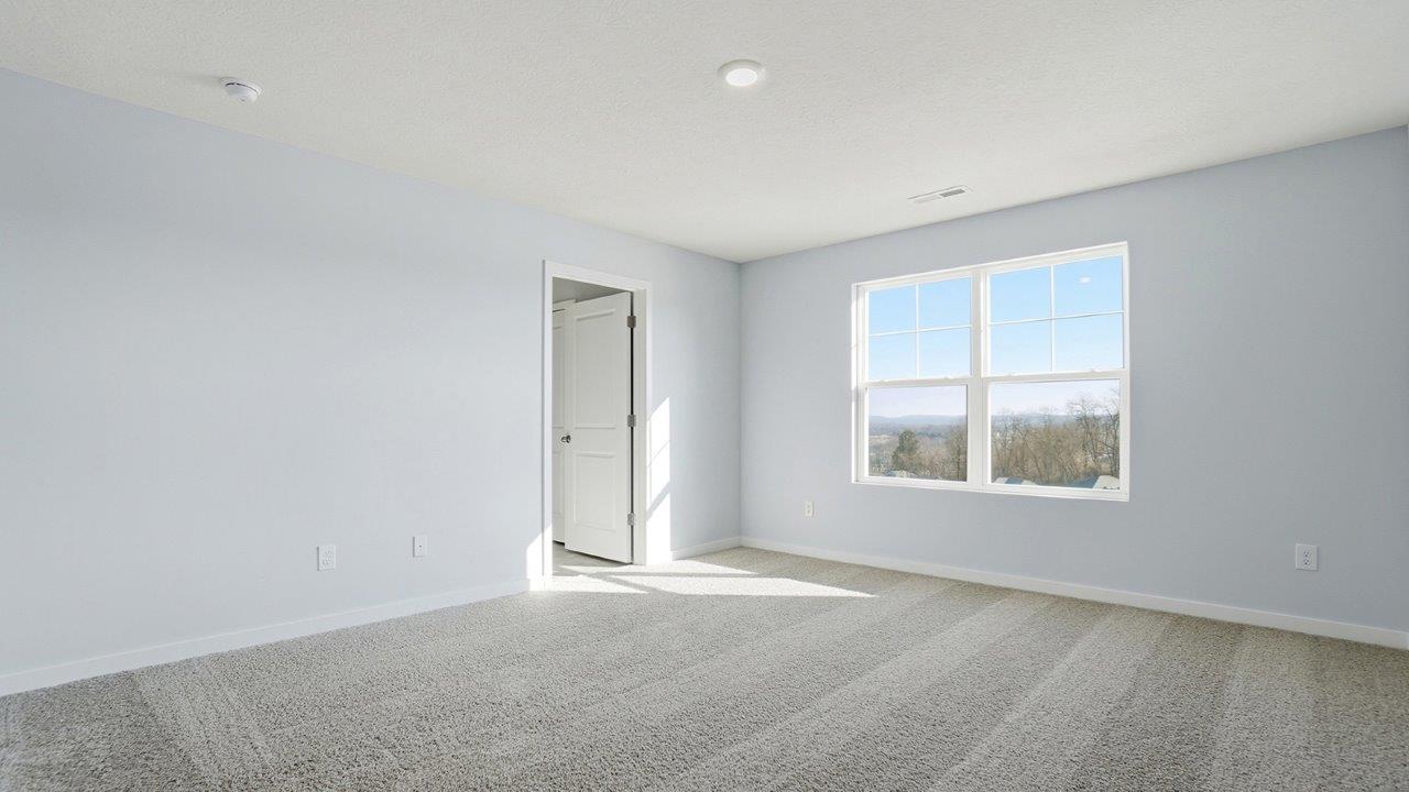 primary bedroom with double window, ensuite bath entry