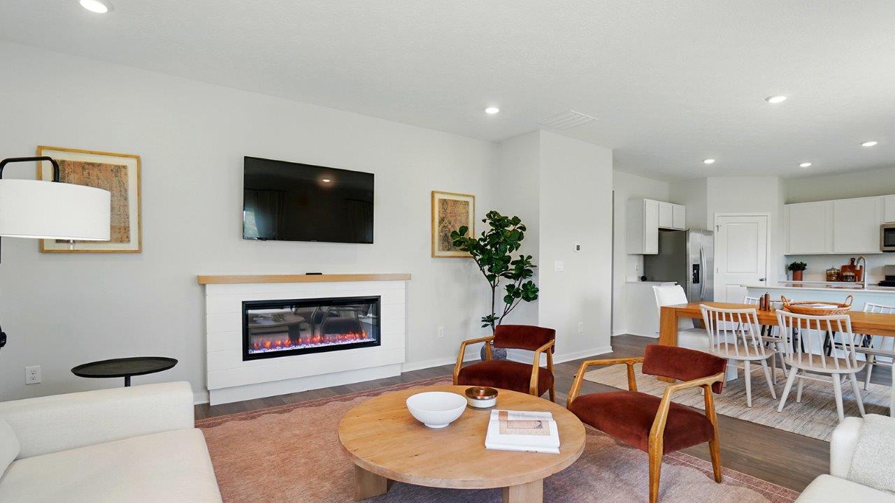 Living room featuring a white sectional against 2 windows, an orange rug and 2 red accent chairs