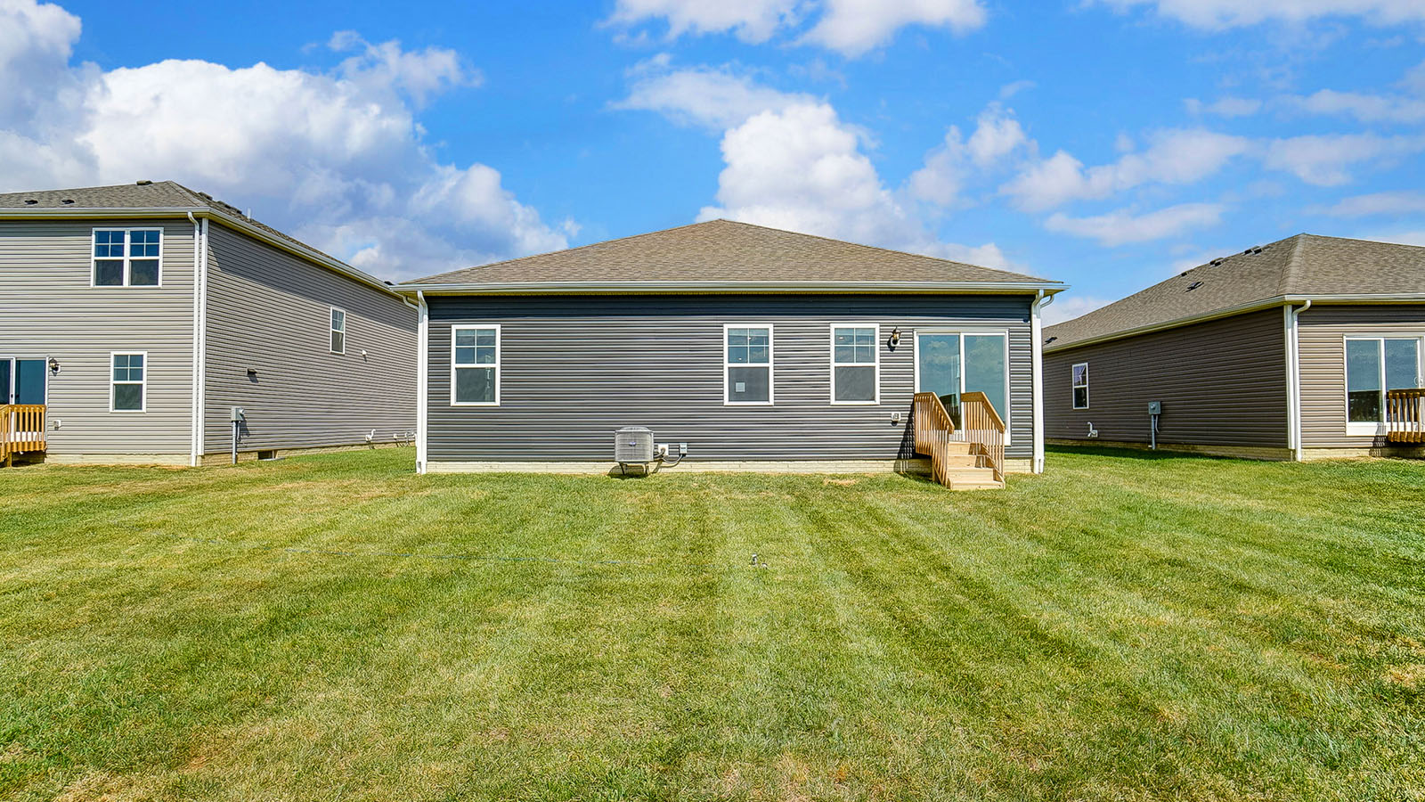 single story home with grey siding rear exterior