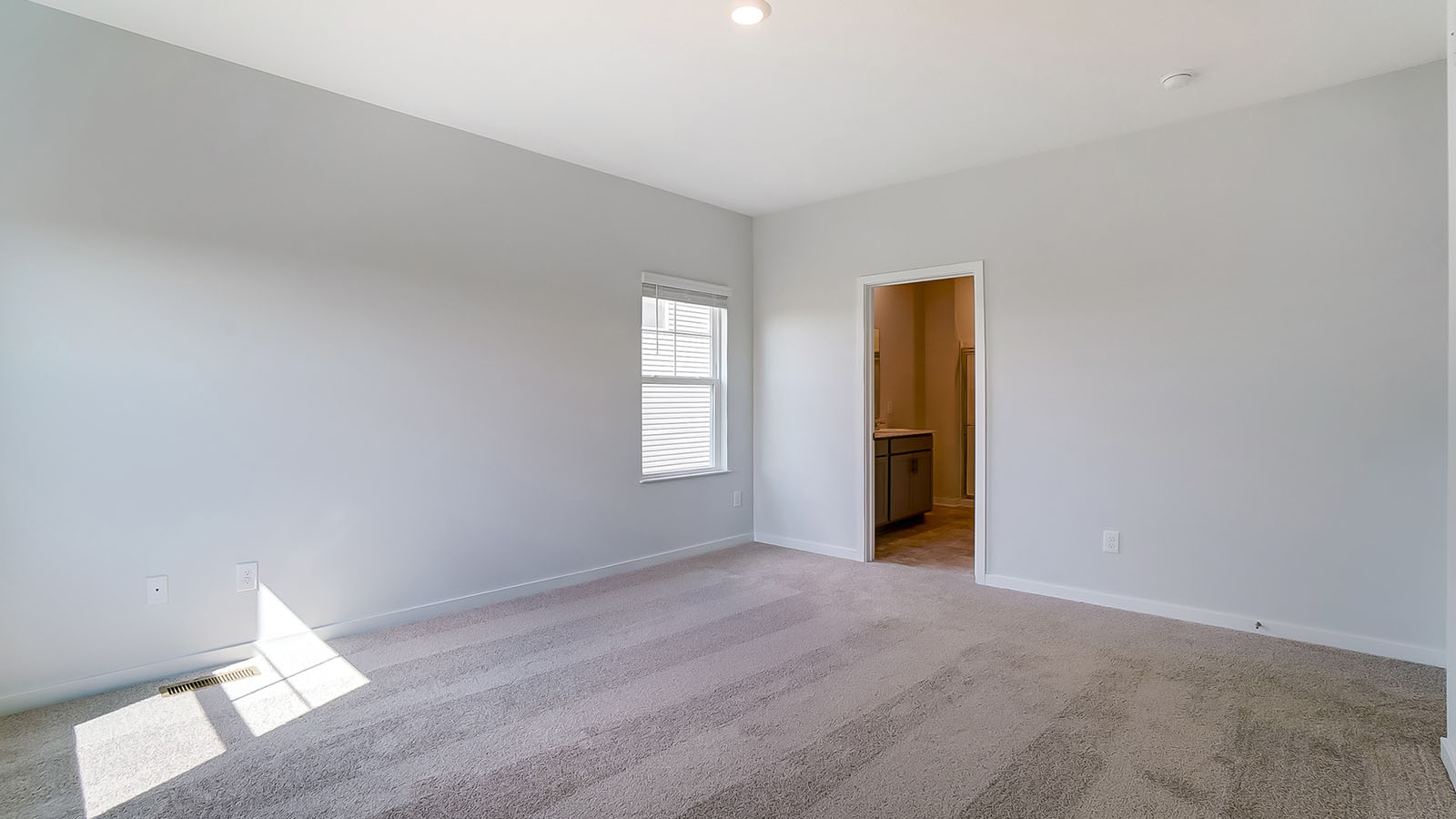 primary bedroom with single window and ensuite bath