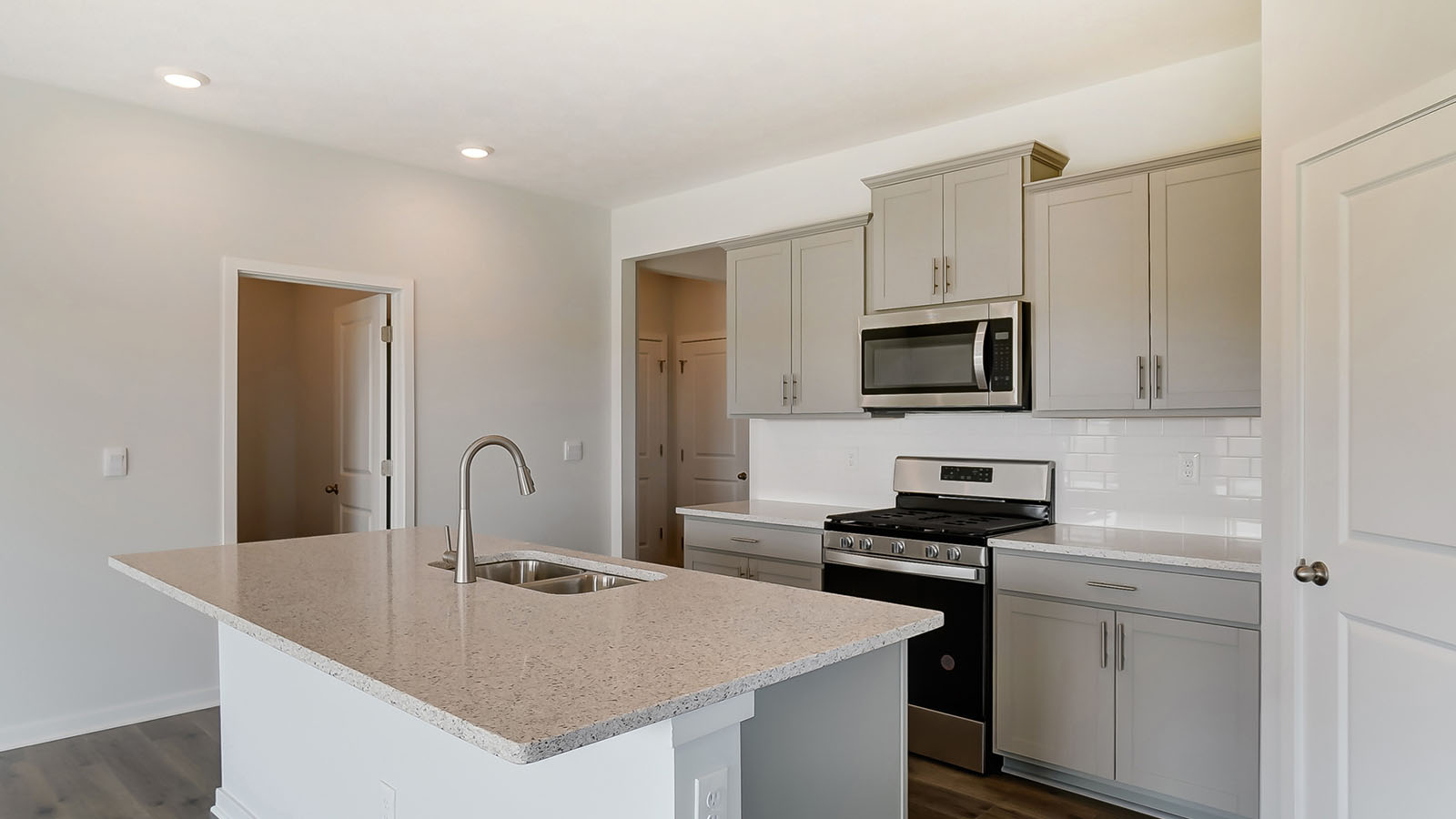 grey kitchen cabinets, stainless steel appliances, built in island