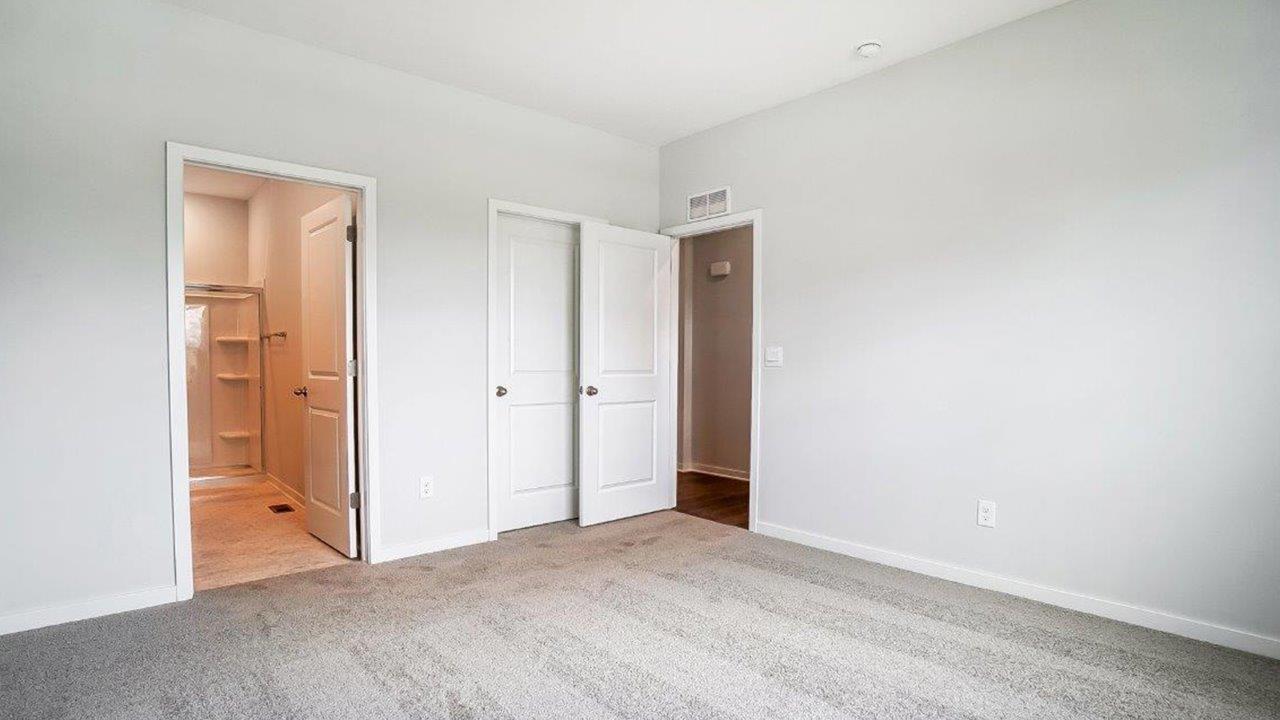 primary bedroom with ensuite bath, walk in closet, entry