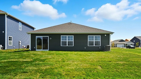 single story home with green siding rear exterior