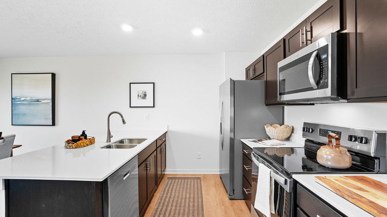 kitchen with brown cabinets, built in island with barstools, stainless steel appliances