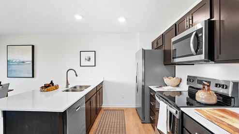 kitchen with brown cabinets, built in island, stainless steel appliances