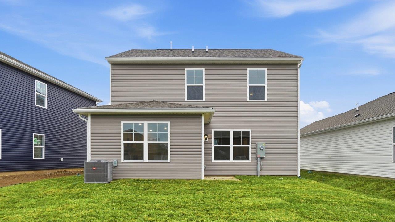 two story home with grey siding rear exterior with dining room bump out