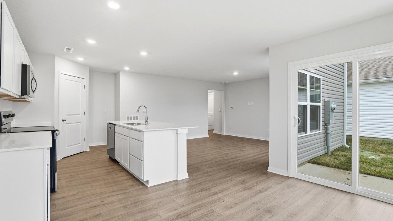 dining space with rear sliding door, kitchen and great room