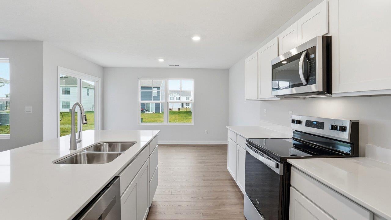 kitchen with white cabinets, built in island, stainless steel appliances, view of dining space