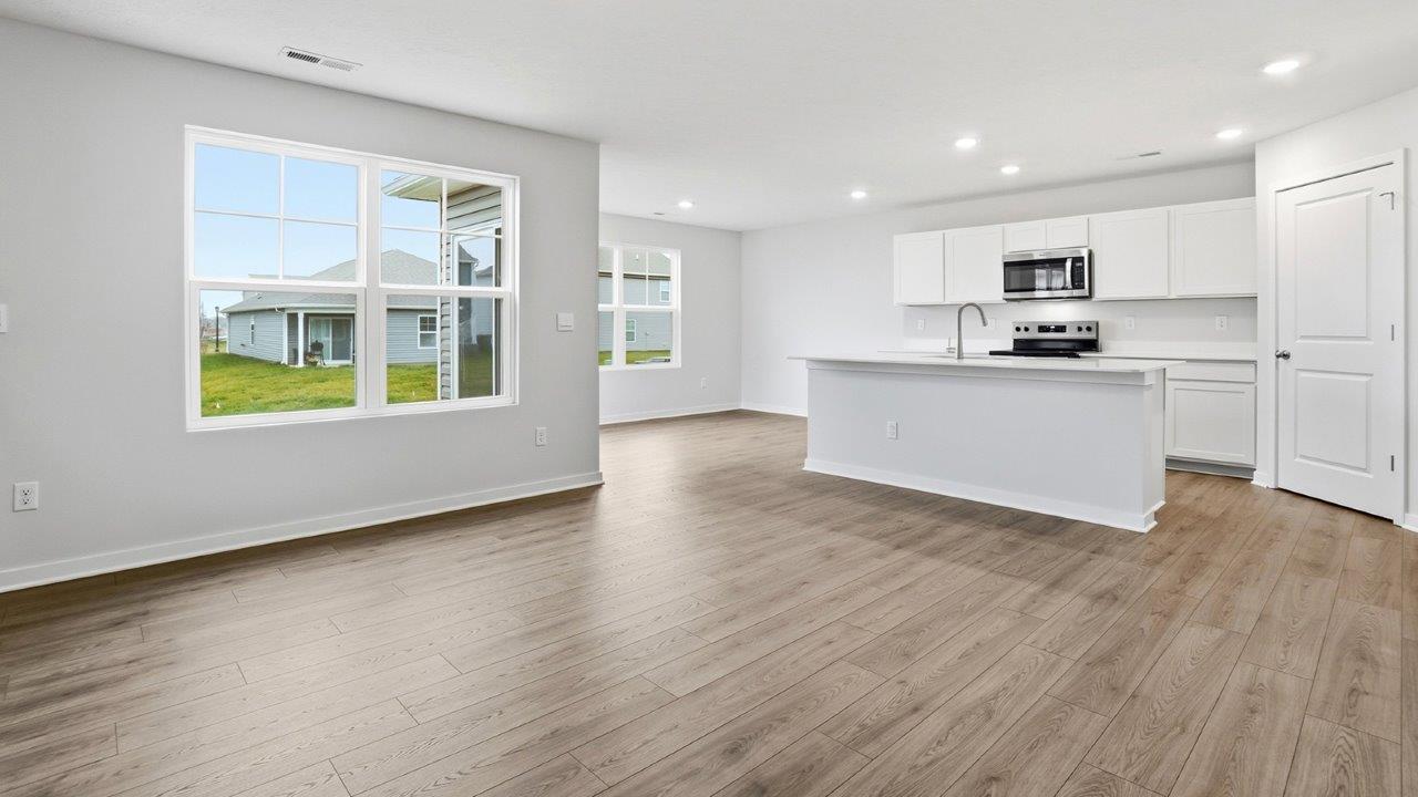 great room with double window, kitchen and dining spaces