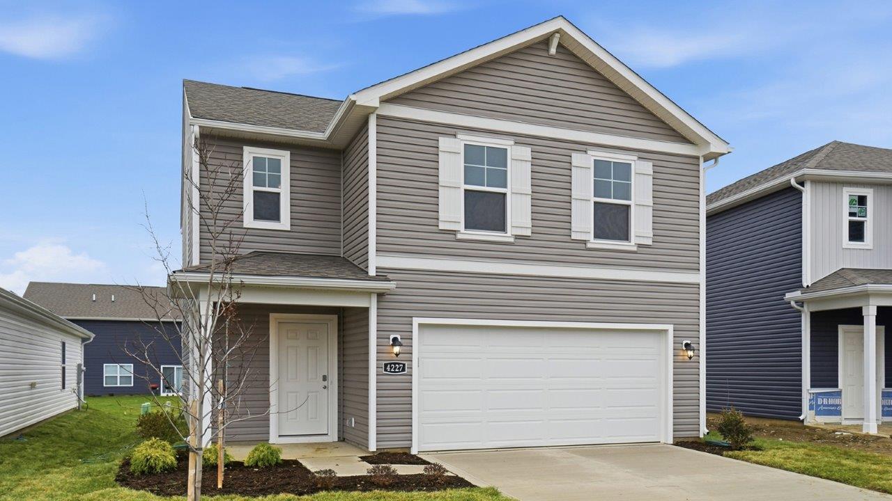two story home with grey siding, covered entry and two car garage