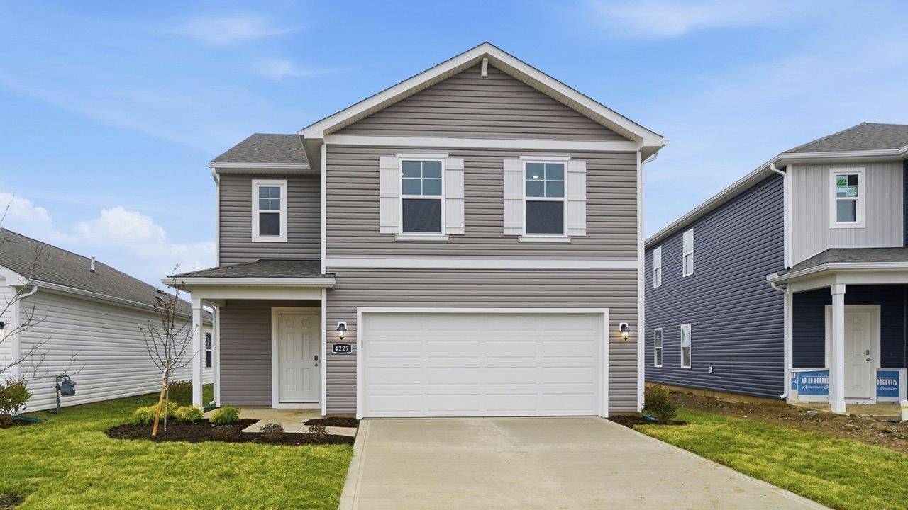two story home with grey siding, covered entry and two car garage