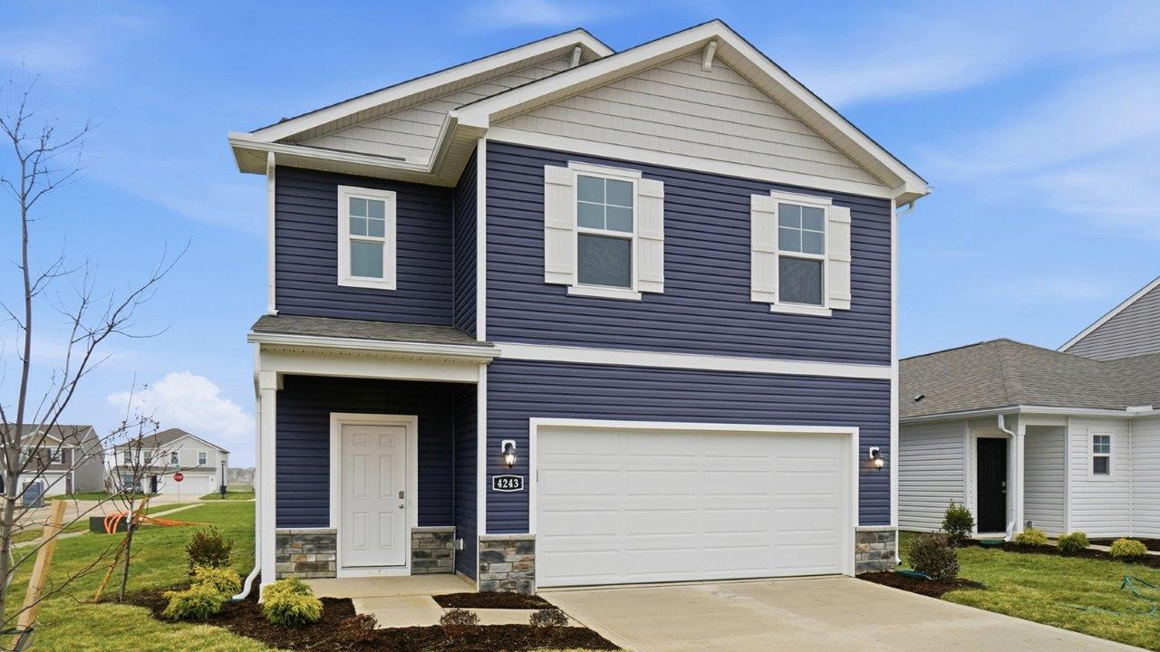 two story home with blue siding, covered entry and two car garage