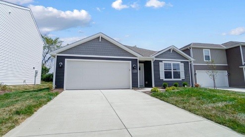 single story home with grey siding, covered entry and two car garage