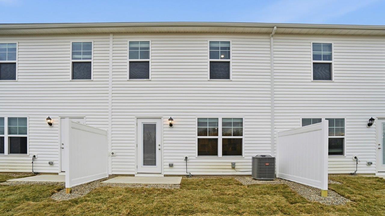 two story townhome with white siding rear exterior