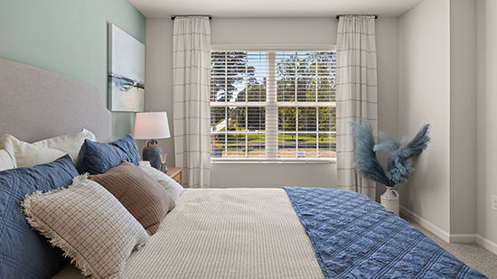 furnished primary bedroom with double window