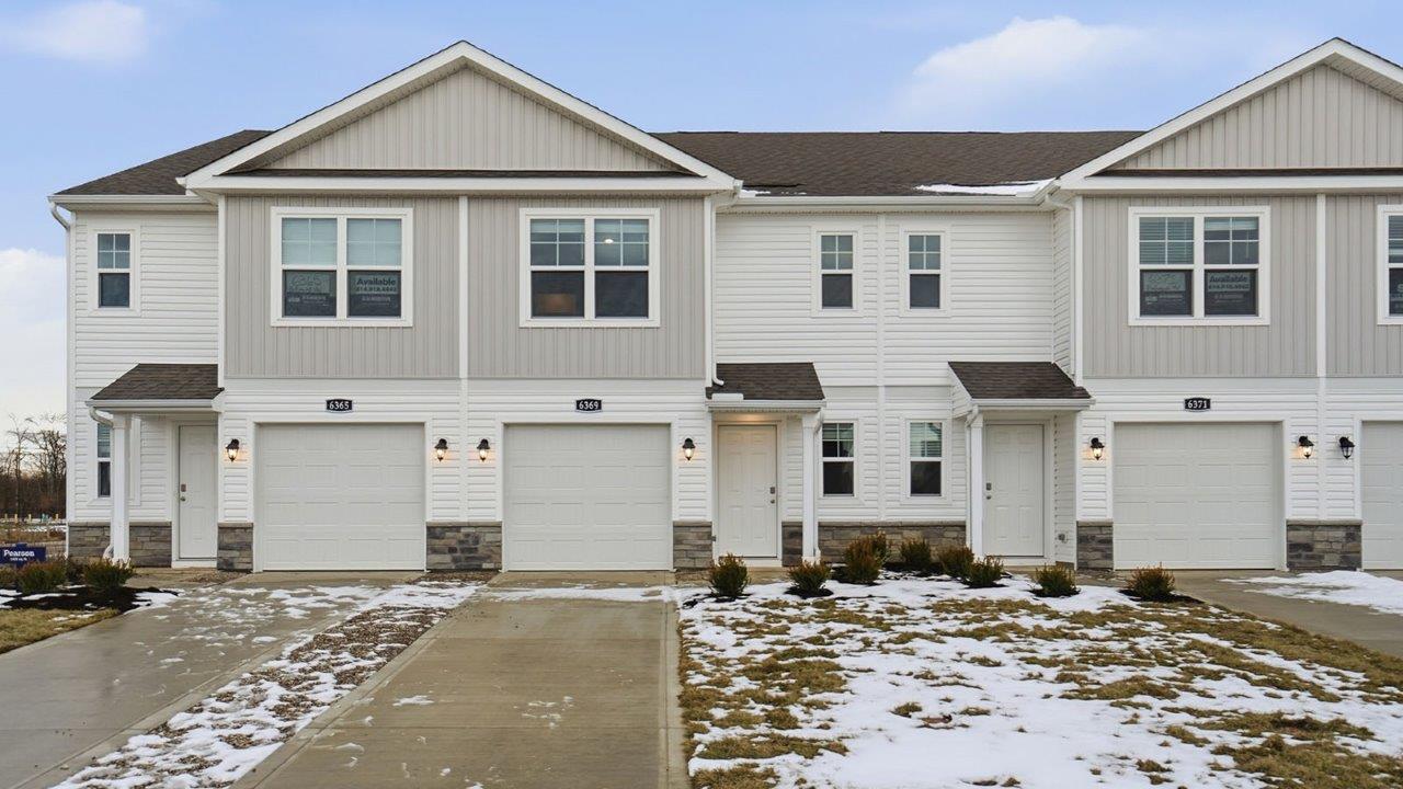 two story townhome with covered entry and one car garage