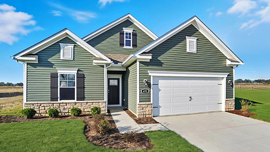 Single story home with green siding, covered entry and two car garage