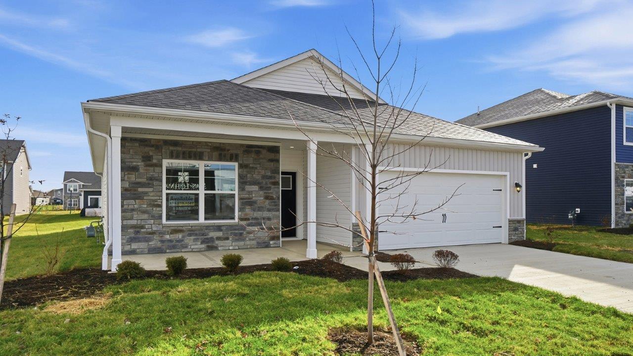 Single story home with grey siding, partial stone front, covered front porch, two car garage