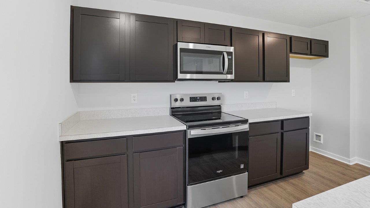 brown cabinets, laminate counters, stainless steel microwave and range