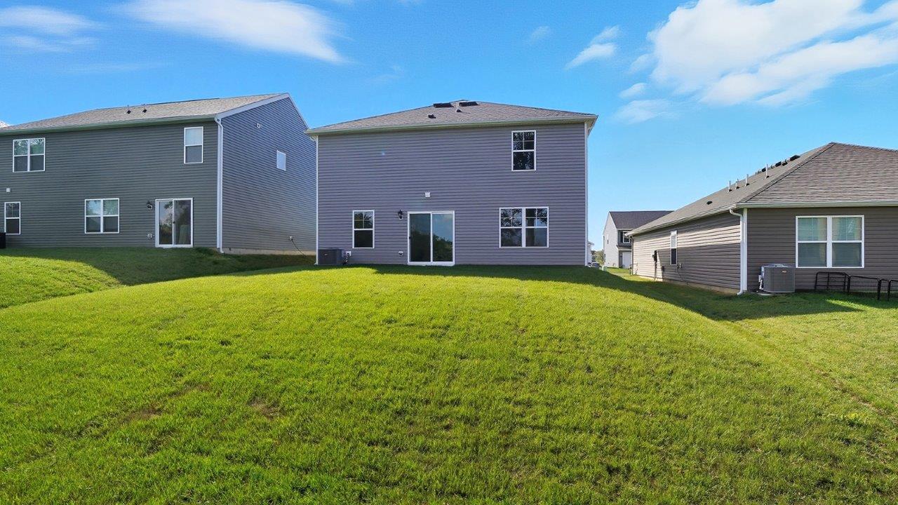 two story home with grey siding and backyard