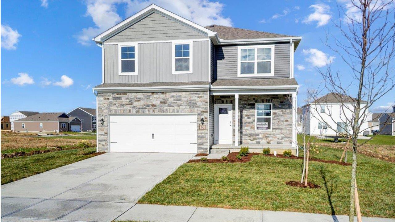 two story home with grey siding, partial stone, covered front porch