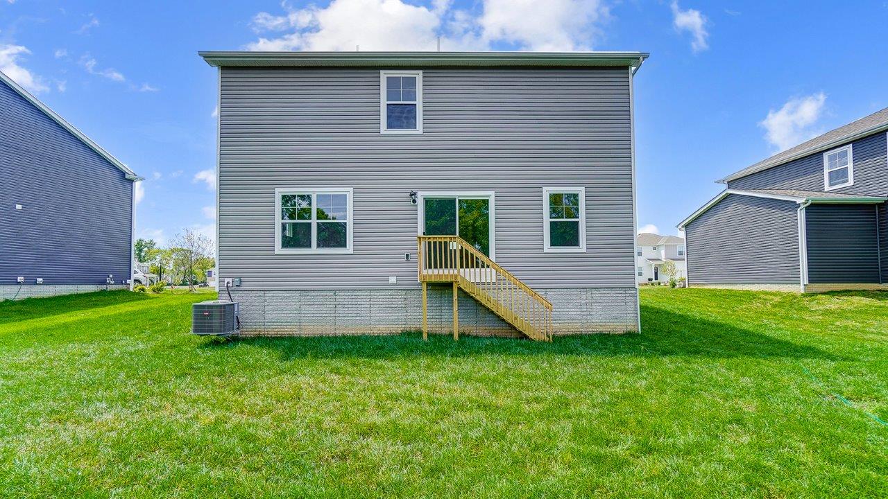 New Build Home by D.R. Horton featuring a spacious backyard with grass lawn