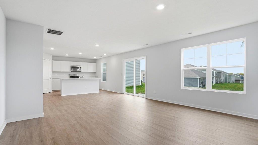 great room with double window and rear sliding door, kitchen