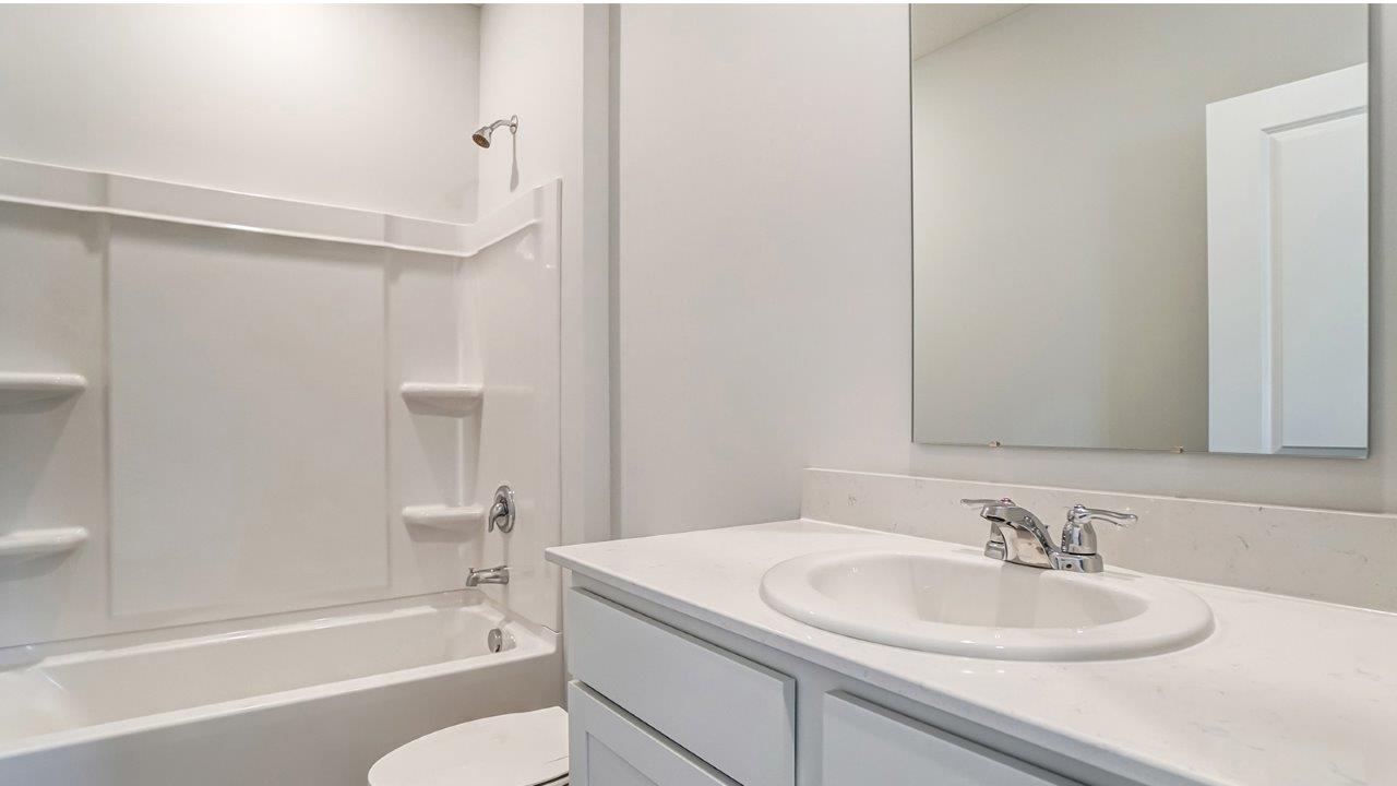 second full bath with single vanity, bath tub and toilet