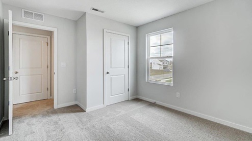 third bedroom doorway, closet and window