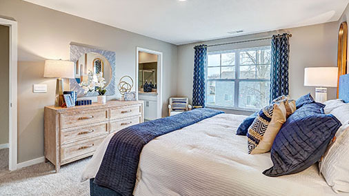 furnished primary bedroom with double window and ensuite bathroomq