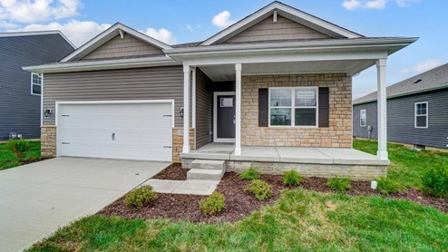 single story home with tan siding, partial stone front, covered front porch, two car garage - Harmony floor plan