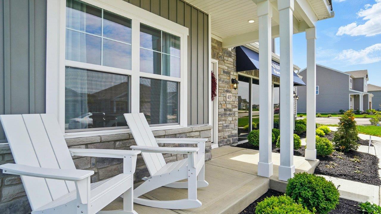 Covered entry porch featuring white rocking chair