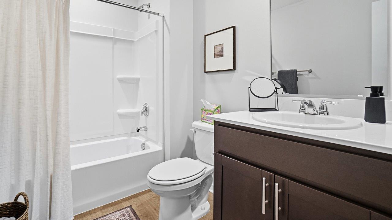 Secondary bathroom w/ dark cabinets