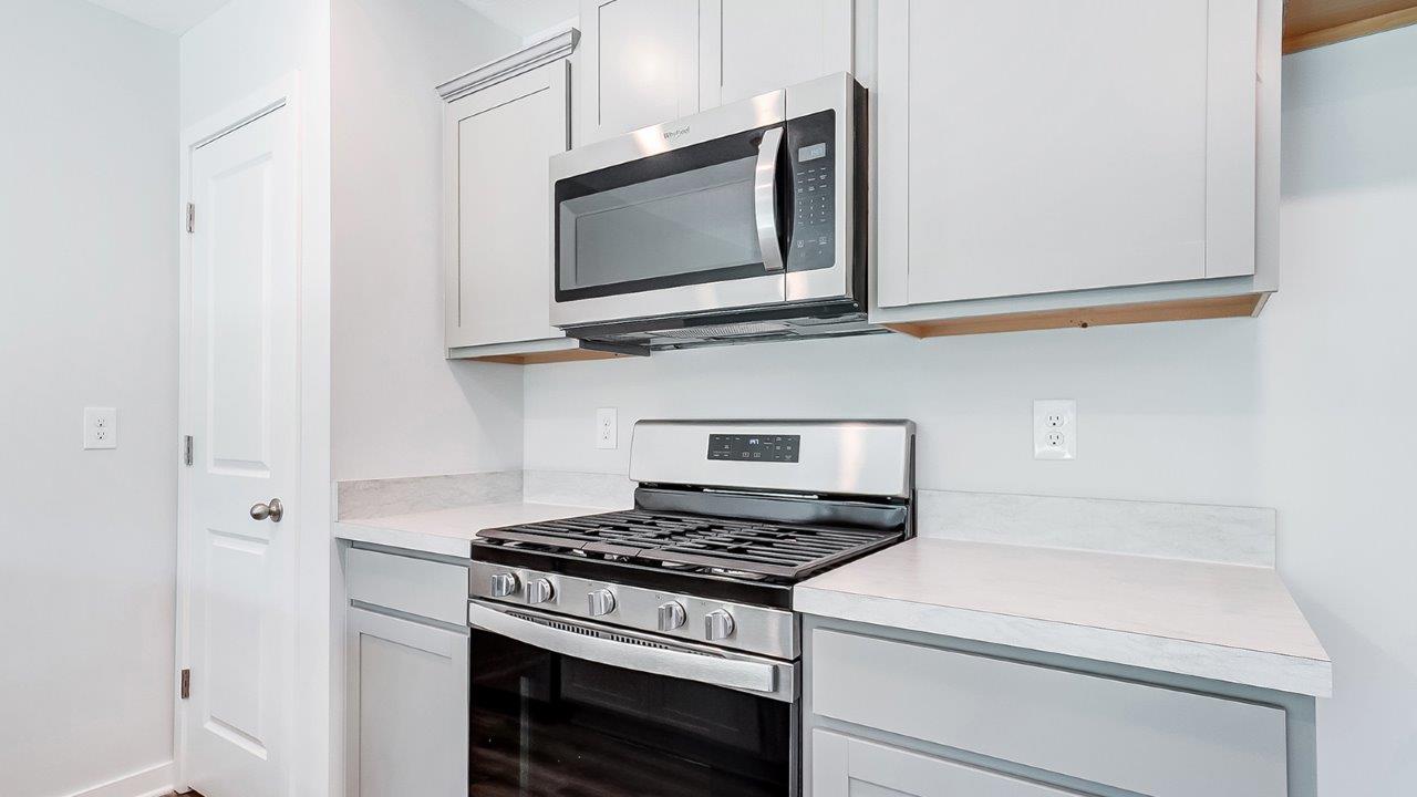 pantry, grey cabinets, stainless steel microwave and range