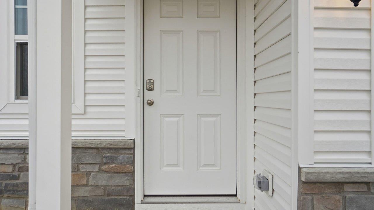 covered entry with white siding, stone water table and white font f