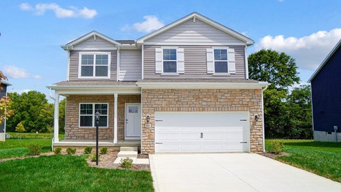 two story home with grey siding, partial stone front, covered front porch and two car garage