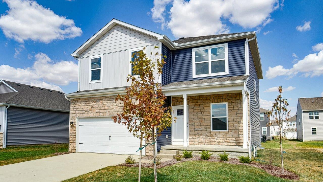 Two story home with blue and grey siding, partial stone front, covered front porch