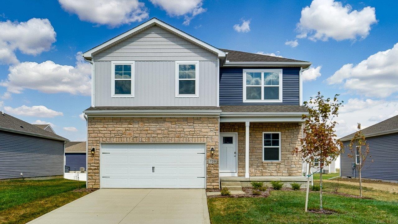 Two story home with blue and grey siding, partial stone front, covered front porch